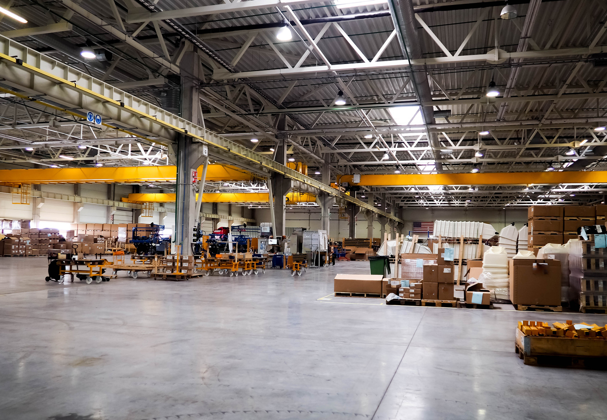 Warehouse industrial premises for storing materials and wood, there is a forklift for containers. Concept logistics, transport. Motion blur effect. Bright sunlight.